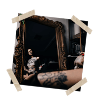 a woman with tattoos in front of a mirror